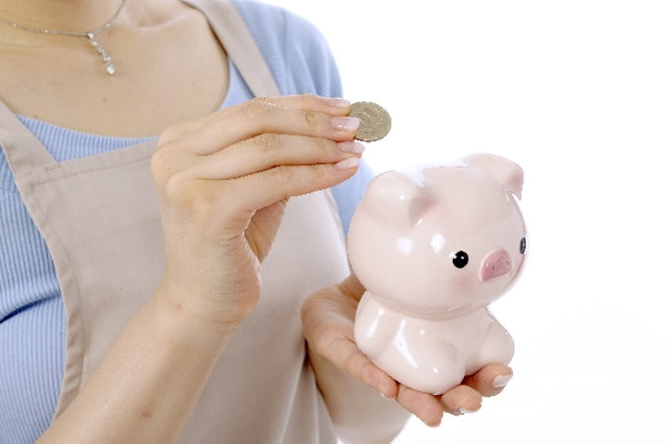 Woman is trying to put a 500-yen coin in the piggy bank of the pig