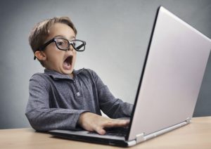 Shocked and surprised boy on the internet with laptop computer concept for amazement, astonishment, making a mistake, stunned and speechless or seeing something he shouldn't see