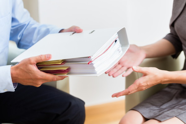 Financial consulting - customer handing over documents to consultant for further analysis